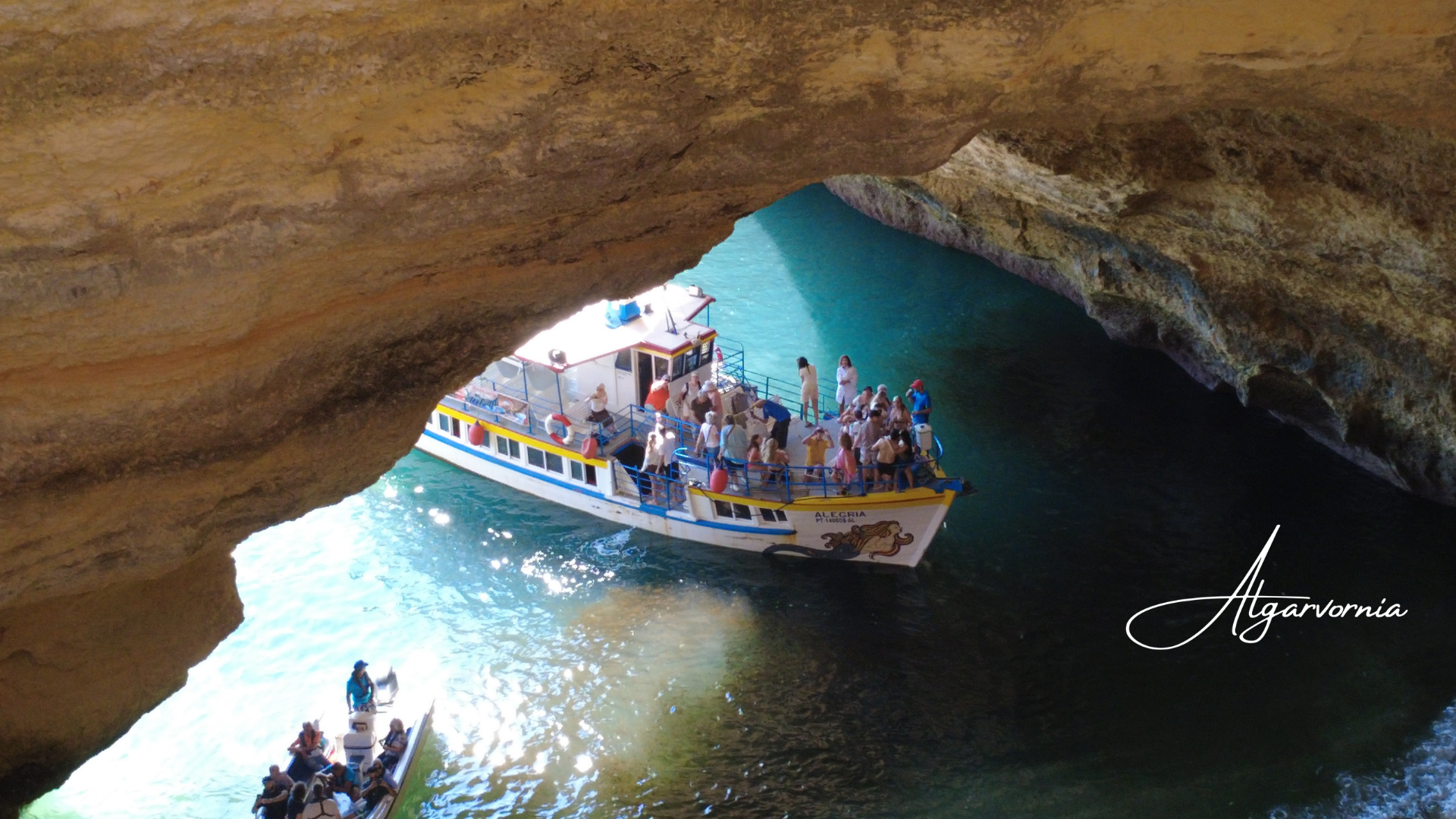 a tourism boat with people entering a sea cave