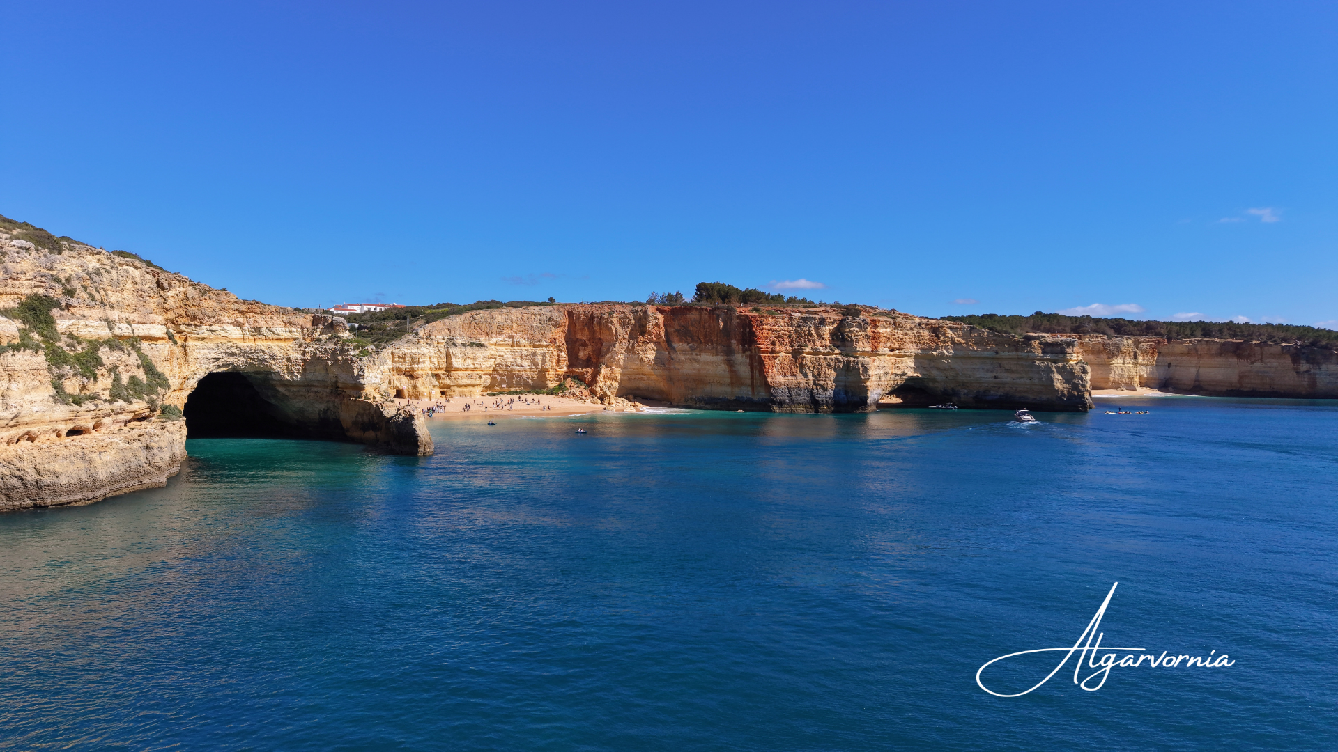 blue ocean with coastline showing a beach and cliffs in the background
